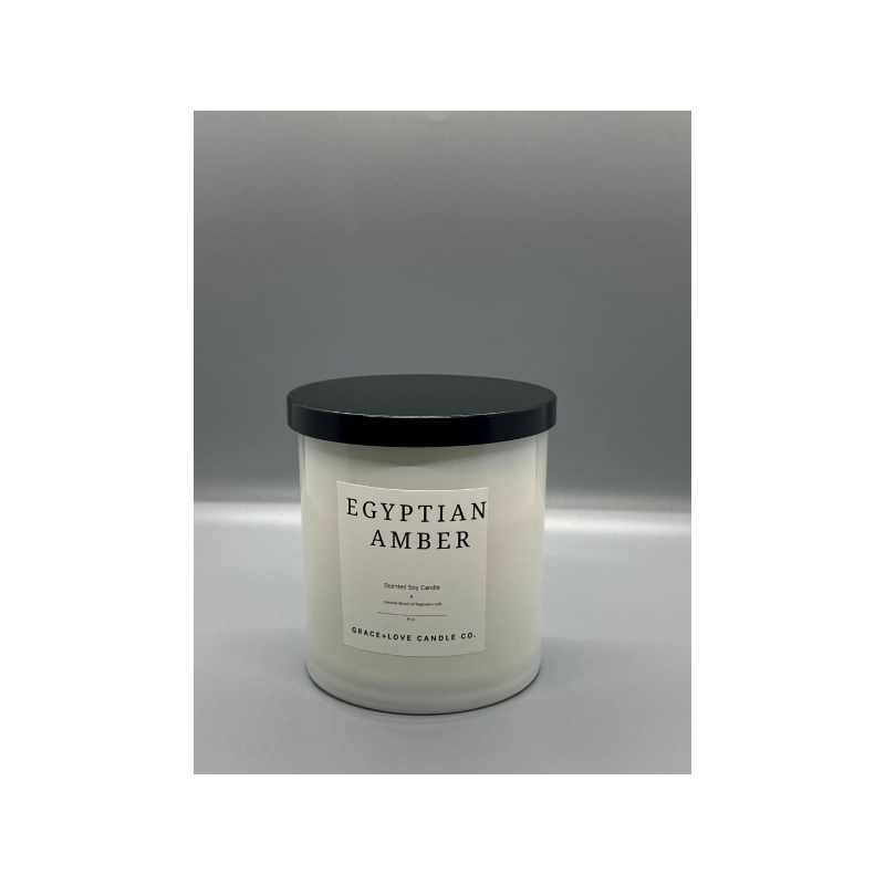 Egyptian Amber soy wax candle in a minimalist white jar with a black lid.