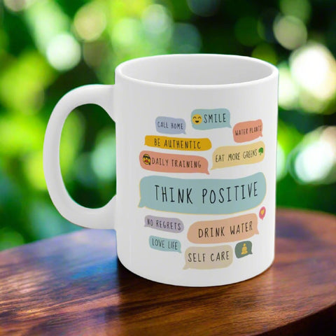 White ceramic mug with positive affirmations outdoors in natural light.