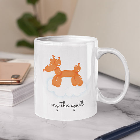 White mug with an orange balloon dog illustration and the text 'my therapist.'