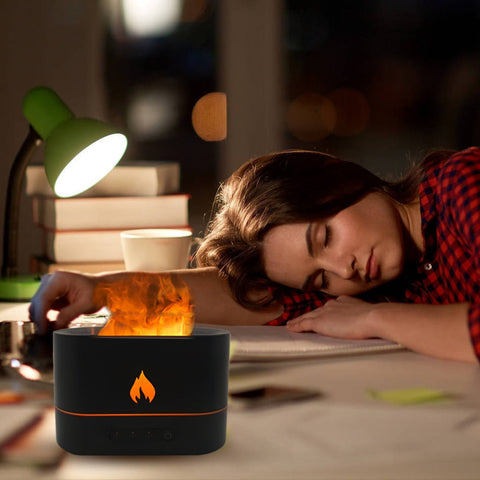 Woman resting near a black flame diffuser with a warm, calming flame effect.