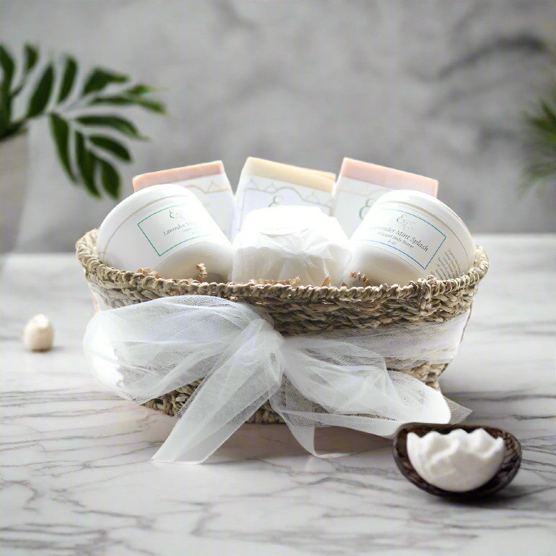 Luxurious spa gift basket with soaps, bath bomb, scrub and body butter wrapped in a ribbon.