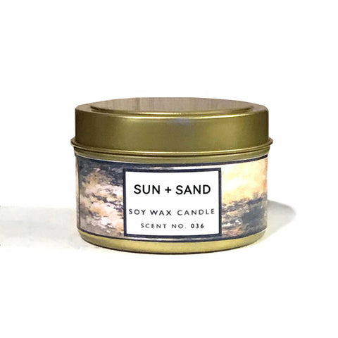 Sun + Sand soy wax candle in a gold metal tin with a minimalist design label.