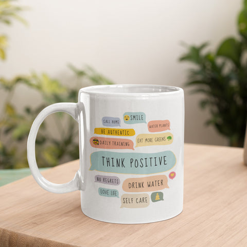 White ceramic mug with positive affirmations on a wooden table.